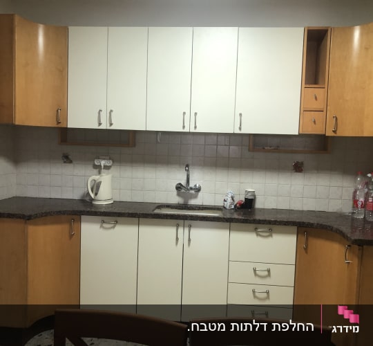 מטבח עם ארונות עץ, קומקום חשמלי וכיור